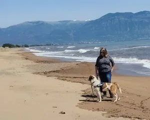 Winter hiking on the beach in greece with my dog in hiking gear.